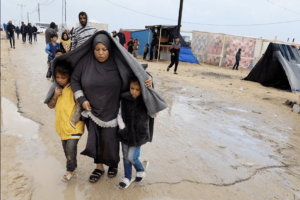 Displaced Palestinians, who fled their houses due to Israeli strikes, walk following heavy rains at tent camps, as the conflict between Israel and Hamas continues, in Rafah, in the southern Gaza Strip December 13, 2023. REUTERS